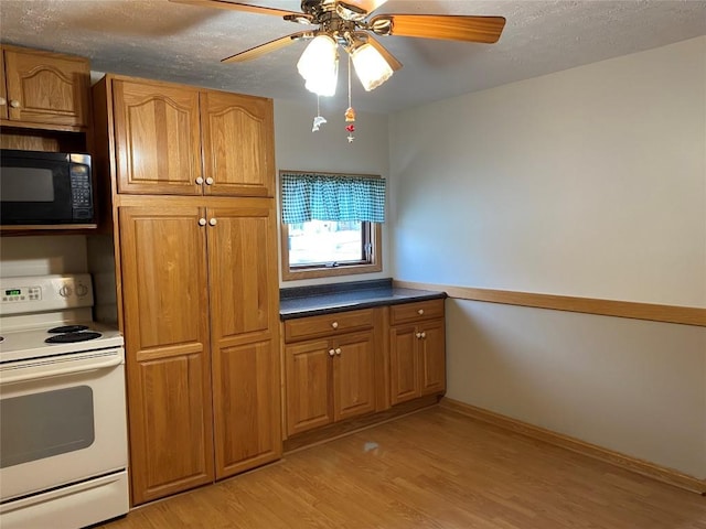 kitchen featuring white electric range oven, ceiling fan, light wood-type flooring, and a textured ceiling