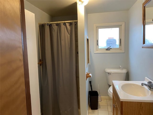 bathroom featuring toilet, vanity, tile patterned floors, and a healthy amount of sunlight