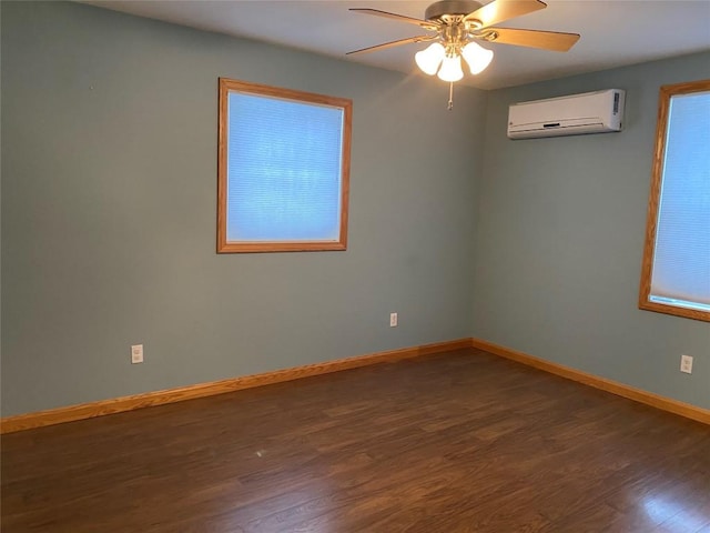 unfurnished room with a wealth of natural light, dark hardwood / wood-style floors, an AC wall unit, and ceiling fan