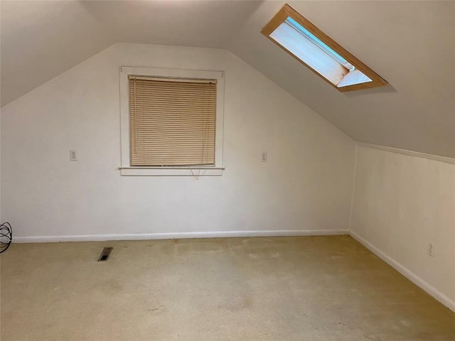 bonus room with lofted ceiling with skylight and light carpet