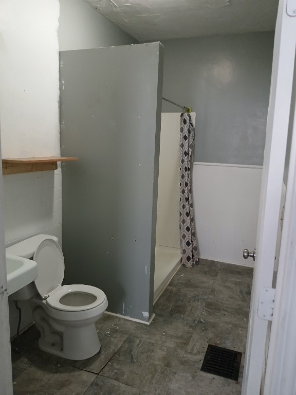 bathroom featuring toilet and a shower with shower curtain