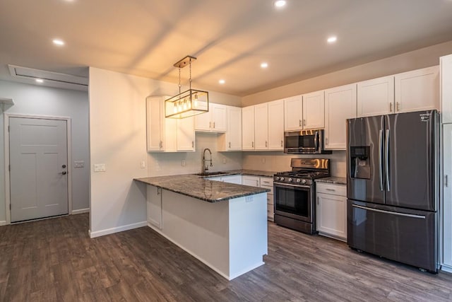 kitchen featuring sink, stainless steel appliances, kitchen peninsula, pendant lighting, and white cabinets