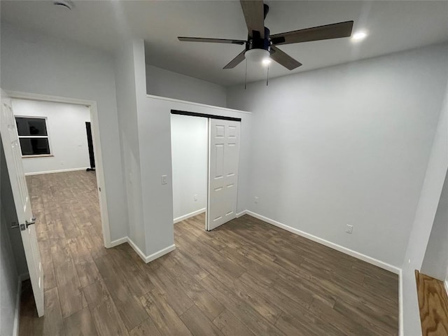 unfurnished bedroom with ceiling fan, dark hardwood / wood-style flooring, and a closet