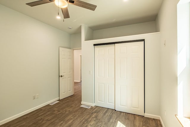 unfurnished bedroom with ceiling fan, dark wood-type flooring, and a closet