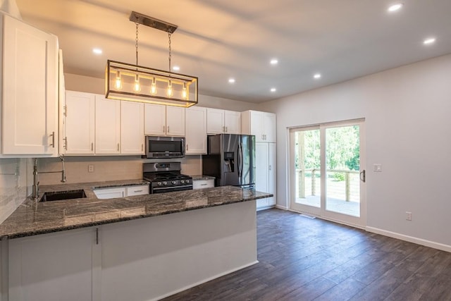 kitchen featuring kitchen peninsula, appliances with stainless steel finishes, sink, white cabinets, and hanging light fixtures