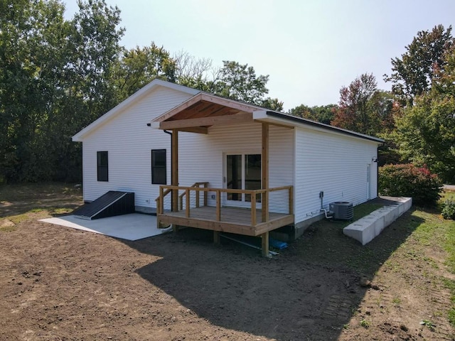 rear view of property featuring central air condition unit and a wooden deck