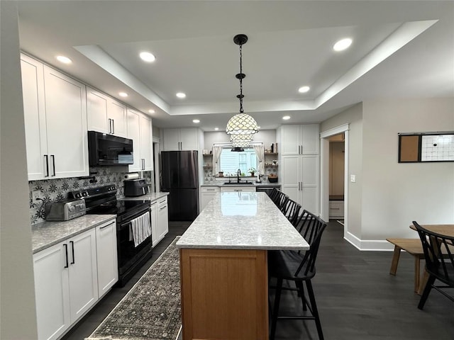 566 Walnut St, Meadville, PA 16335 - kitchen featuring black appliances, a raised ceiling, decorative backsplash, a breakfast bar, and recessed lighting