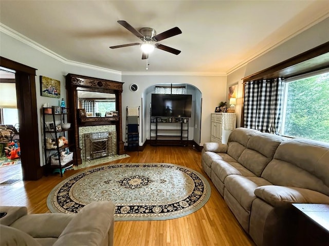 566 Walnut St, Meadville, PA 16335 - living room with wood finished floors, ornamental molding, ceiling fan, a fireplace with flush hearth, and arched walkways