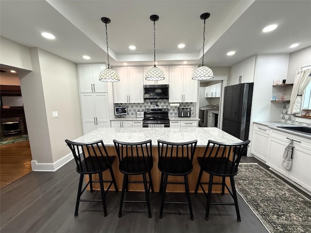 566 Walnut St, Meadville, PA 16335 - kitchen with black appliances, dark wood-style flooring, washer and clothes dryer, backsplash, and a kitchen island