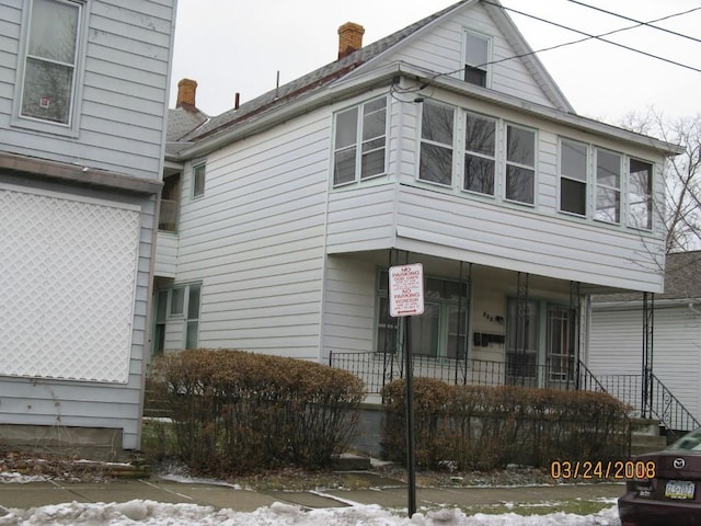 exterior space featuring a porch and a chimney