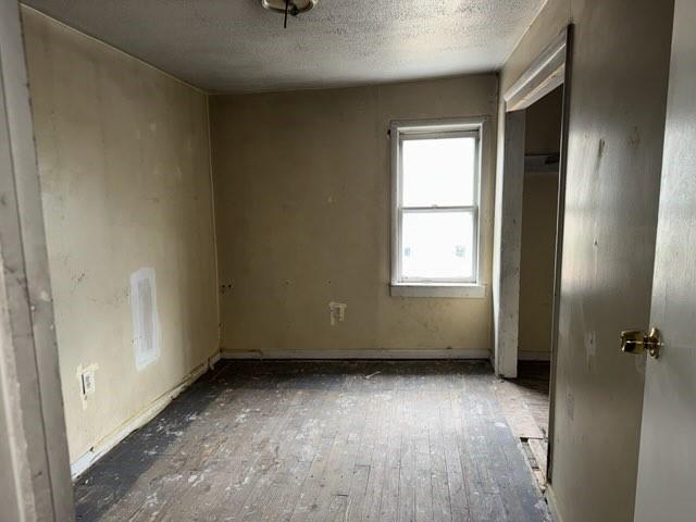 513 Wallace St, Erie, PA 16507 - unfurnished bedroom with a closet, a textured ceiling, and wood finished floors