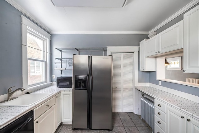 kitchen featuring sink, plenty of natural light, black appliances, white cabinets, and dark tile patterned flooring