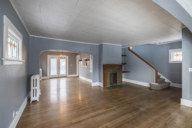 unfurnished living room with crown molding, plenty of natural light, and radiator heating unit