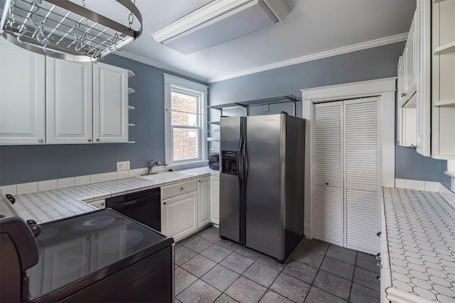 kitchen with tile countertops, white cabinetry, sink, black appliances, and crown molding