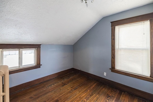 bonus room featuring vaulted ceiling, dark hardwood / wood-style flooring, and a textured ceiling