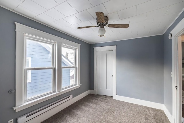 carpeted spare room featuring a baseboard heating unit and ceiling fan