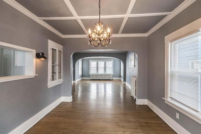 hallway featuring coffered ceiling, ornamental molding, a chandelier, and a healthy amount of sunlight