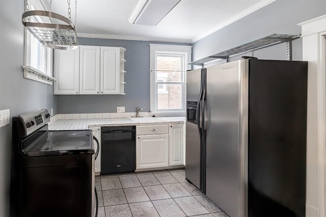 kitchen with light tile patterned floors, stainless steel appliances, ornamental molding, white cabinets, and tile countertops