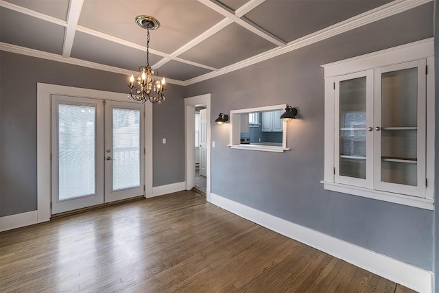 interior space featuring french doors, dark wood-type flooring, coffered ceiling, a chandelier, and ornamental molding