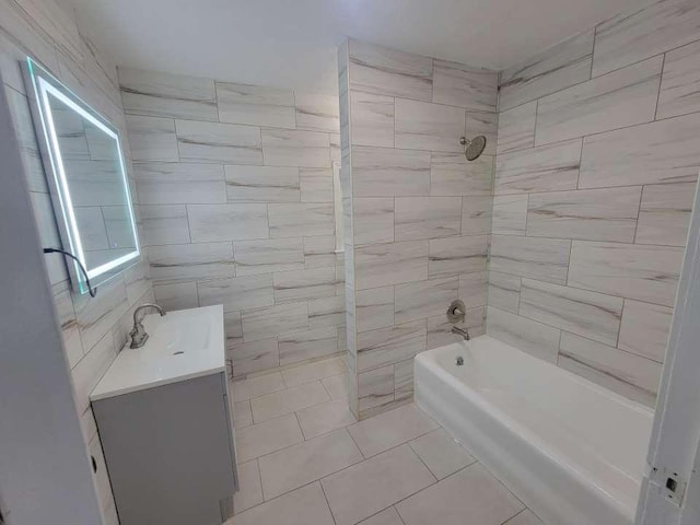 bathroom featuring vanity, tile patterned floors, and tiled shower / bath