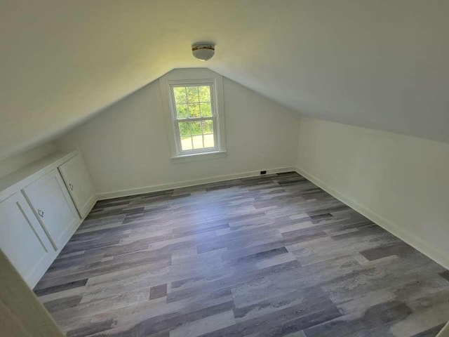 bonus room with hardwood / wood-style flooring and lofted ceiling