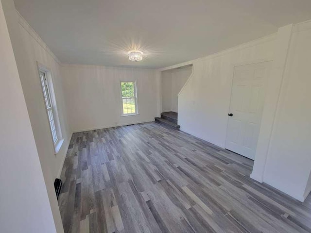 spare room with hardwood / wood-style flooring and crown molding