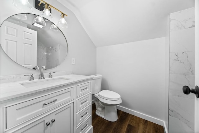 bathroom with a shower, lofted ceiling, toilet, vanity, and hardwood / wood-style flooring