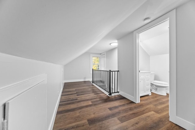 hallway featuring dark hardwood / wood-style floors and vaulted ceiling