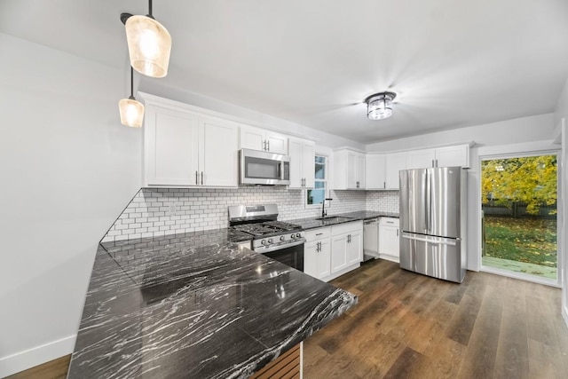 kitchen with decorative backsplash, stainless steel appliances, pendant lighting, dark hardwood / wood-style floors, and white cabinetry