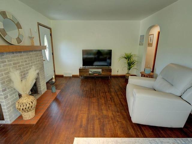 6620 W Ridge Rd, Fairview, PA 16415 - living room featuring arched walkways, hardwood / wood-style floors, a fireplace, and baseboards