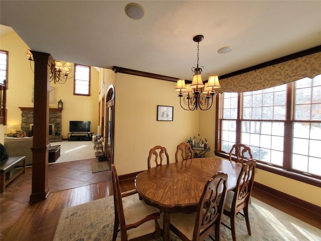 dining area with hardwood / wood-style floors, baseboards, a chandelier, and crown molding