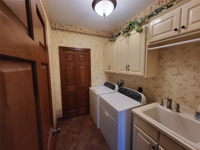 laundry room featuring wallpapered walls, washer and dryer, cabinet space, and a sink