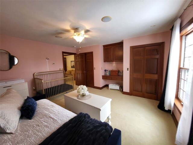 bedroom featuring baseboards, light carpet, and ceiling fan