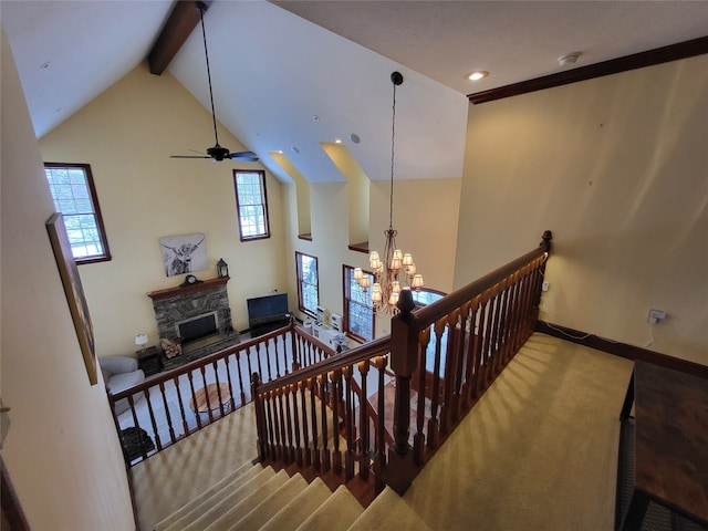 stairs with baseboards, carpet floors, beam ceiling, a fireplace, and high vaulted ceiling