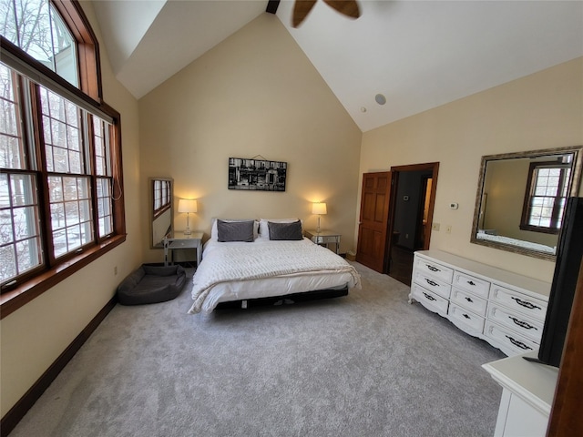 carpeted bedroom featuring multiple windows, high vaulted ceiling, and baseboards