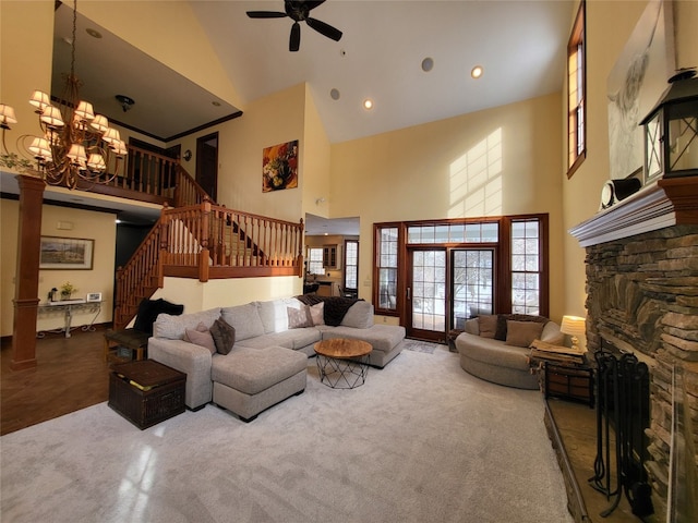 living room featuring stairs, ceiling fan with notable chandelier, plenty of natural light, and a fireplace