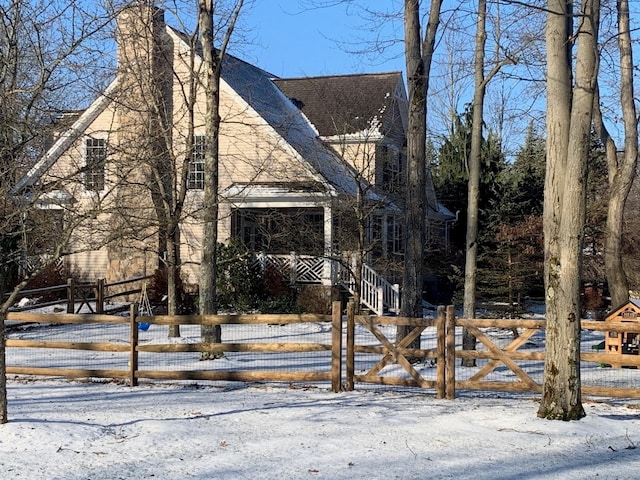 view of front of home with a fenced front yard, a chimney, and roof with shingles