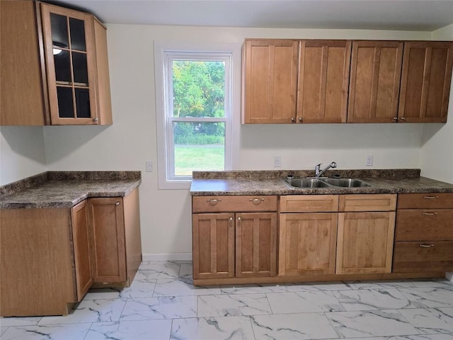 922 E 9th St, Erie, PA 16503 - kitchen featuring light marble finish flooring, dark countertops, glass insert cabinets, and brown cabinets