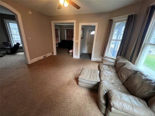 living room with carpet flooring, ceiling fan, and a healthy amount of sunlight