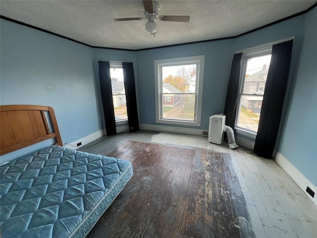 unfurnished bedroom featuring hardwood / wood-style floors, ceiling fan, and a textured ceiling