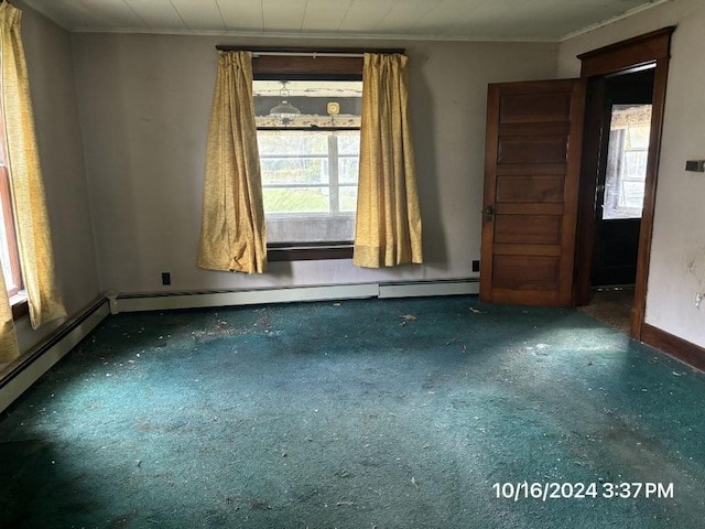 empty room with dark colored carpet, baseboard heating, and ornamental molding