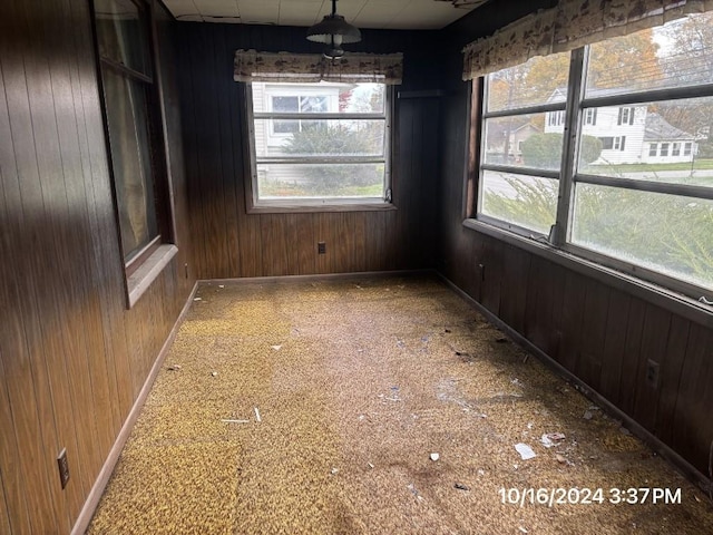 unfurnished dining area featuring wood walls