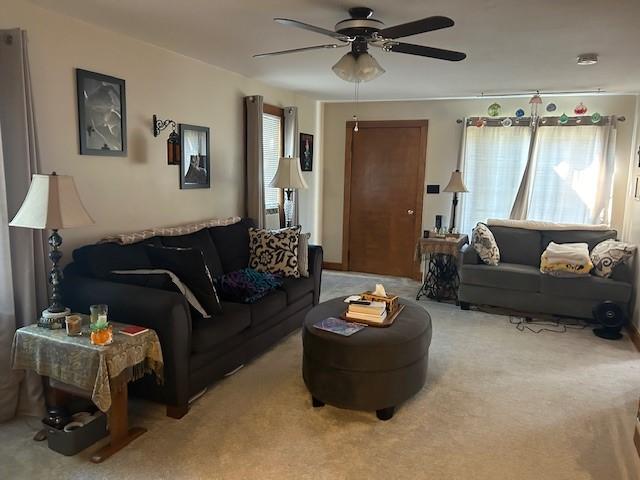 carpeted living room featuring ceiling fan and a healthy amount of sunlight