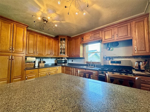 kitchen featuring appliances with stainless steel finishes, a textured ceiling, crown molding, and sink