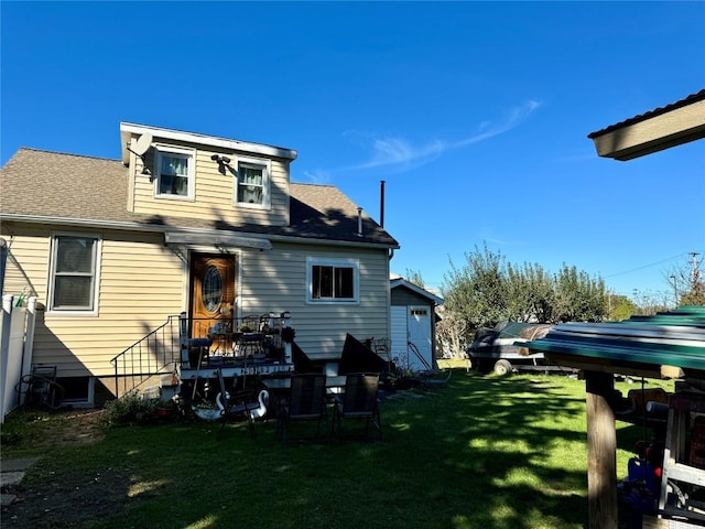 rear view of house featuring a yard