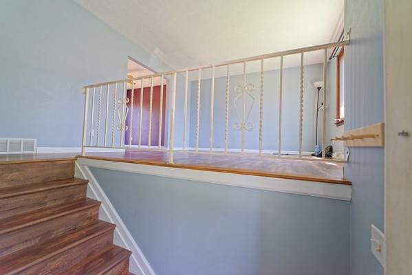 staircase with lofted ceiling and visible vents