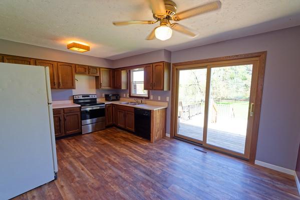 kitchen featuring brown cabinetry, dishwasher, light countertops, freestanding refrigerator, and electric stove