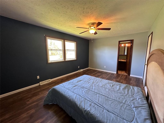 bedroom featuring visible vents, wood finished floors, baseboards, ceiling fan, and a textured ceiling