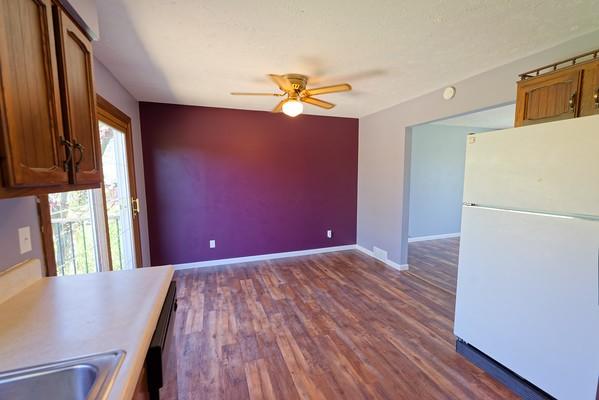 kitchen with freestanding refrigerator, baseboards, ceiling fan, dark wood-type flooring, and a sink