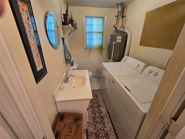 clothes washing area featuring washer and dryer, electric water heater, and sink